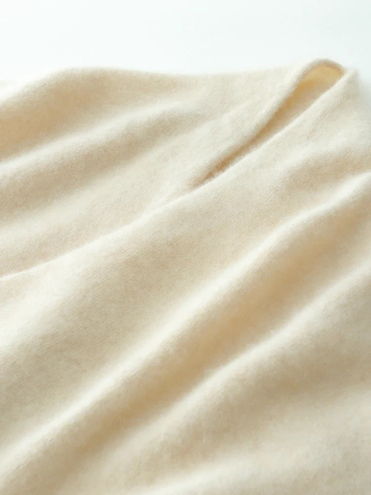 Close-up of cream/beige knit fabric with soft folds and fine, even weave