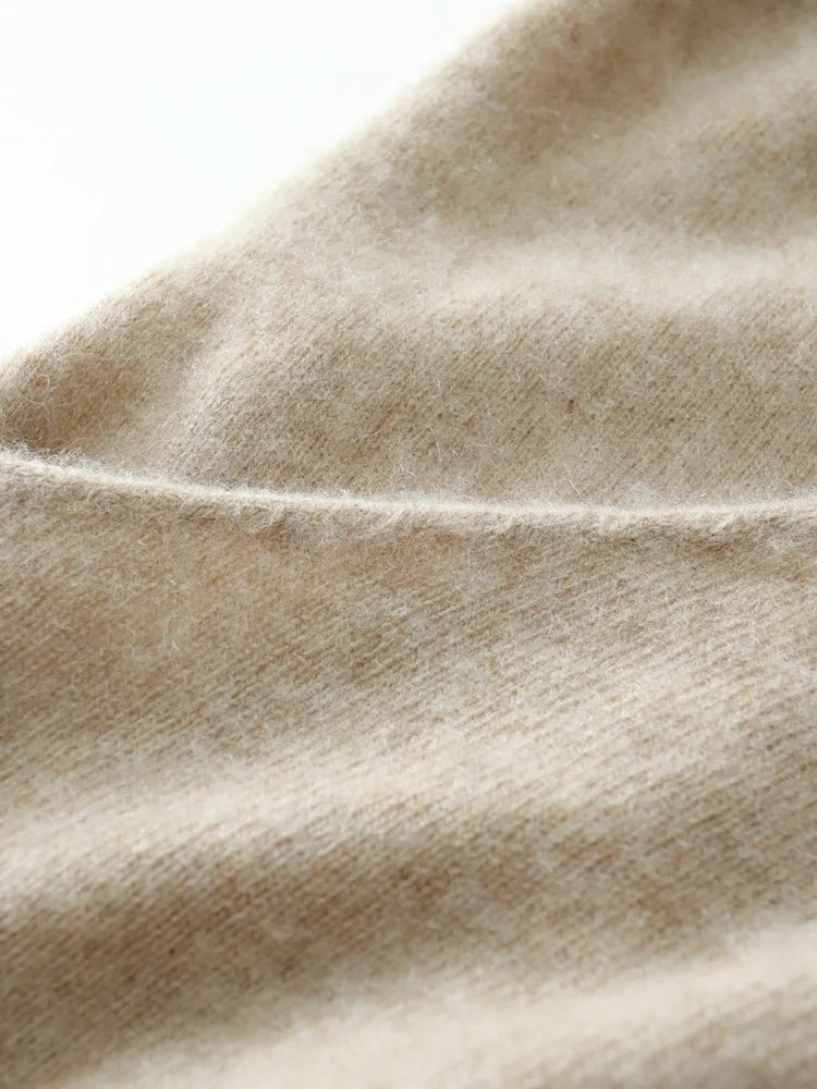 Close-up of beige knit fabric showing fine stitch lines and plush surface
