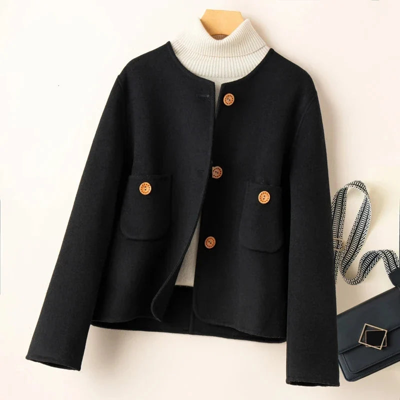 Black button-front jacket with ribbed high collar and two patch pockets.
