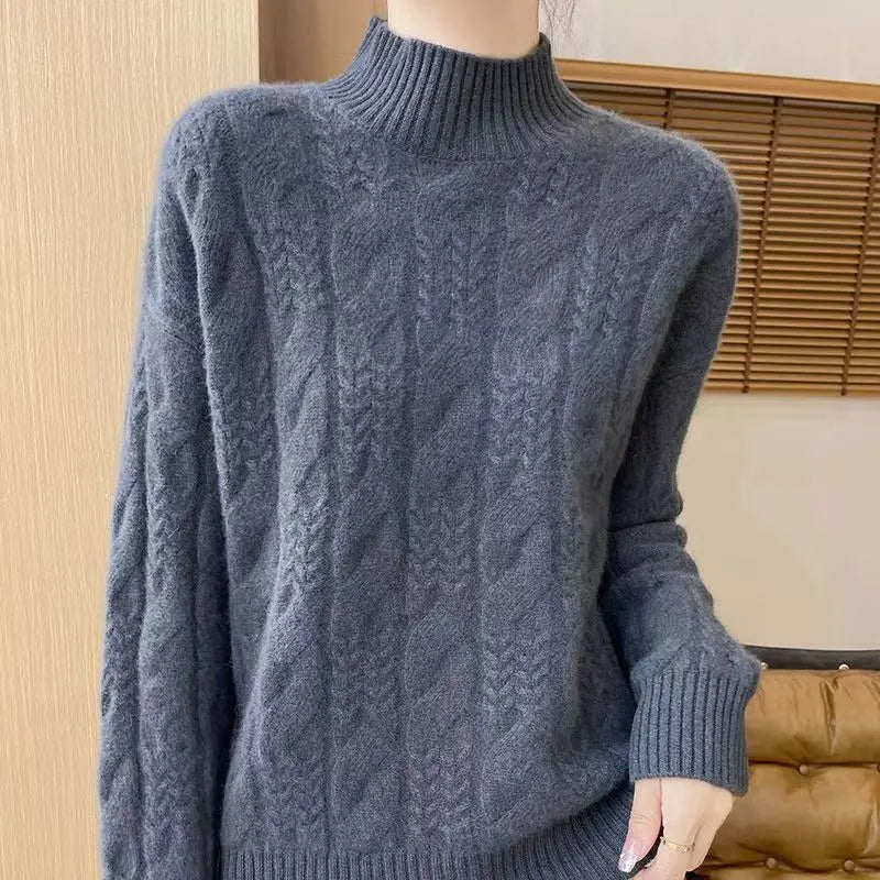 Slate blue cable knit mock neck sweater with raised cable pattern and ribbed cuffs.