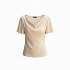 Beige draped cowl-neck blouse with short sleeves and soft neckline drape.
