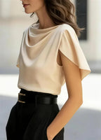 Beige draped cowl-neck blouse with short sleeves and gathered shoulder drape.
