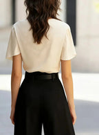Beige draped cowl-neck blouse from back with short sleeves.