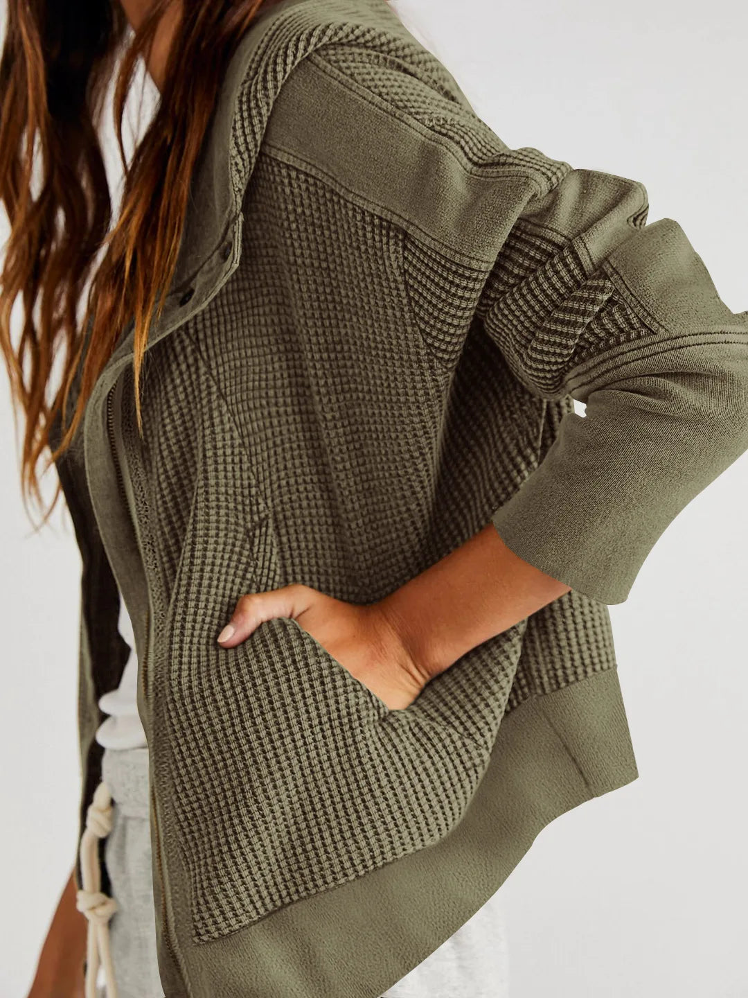 Olive waffle-knit hoodie with long cuffed sleeves and side pocket panel.