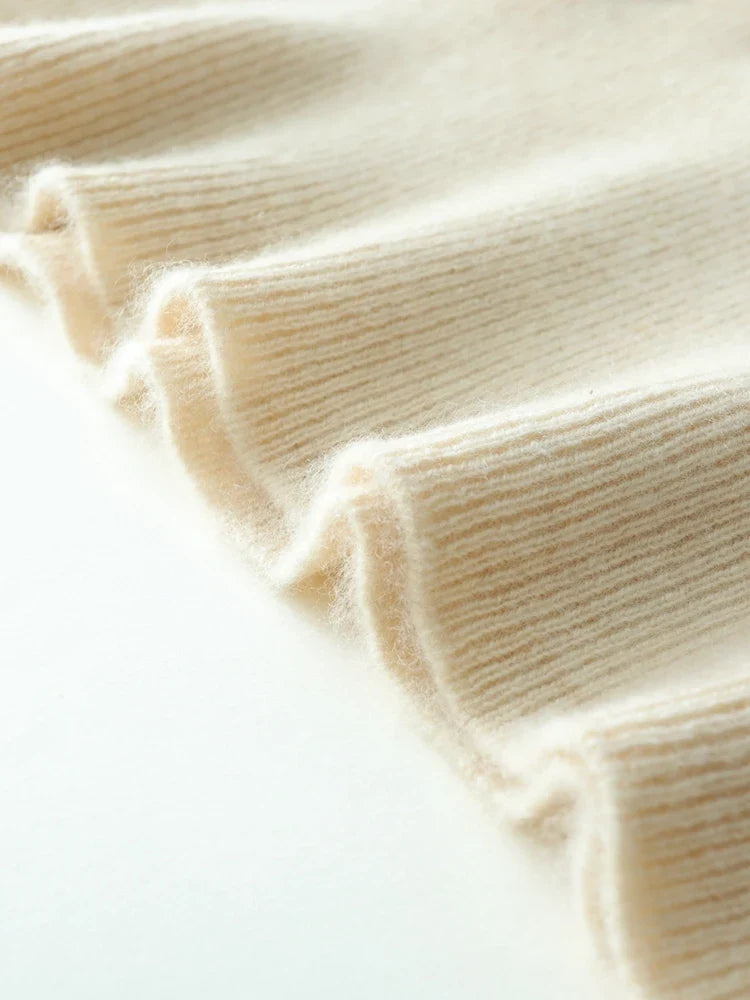 Beige knit sweater ribbed cuff close-up with stitched seam and smooth knit texture