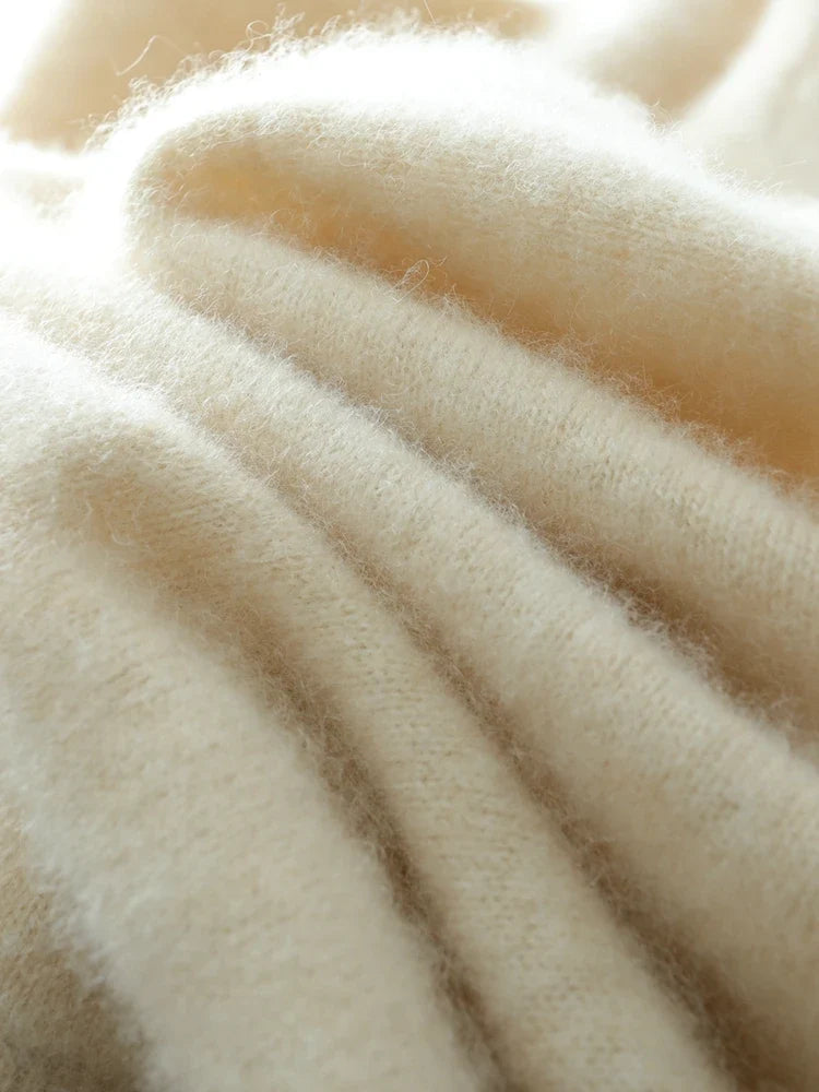 Light beige knit sweater fabric close-up with soft fuzzy texture and neat ribbing