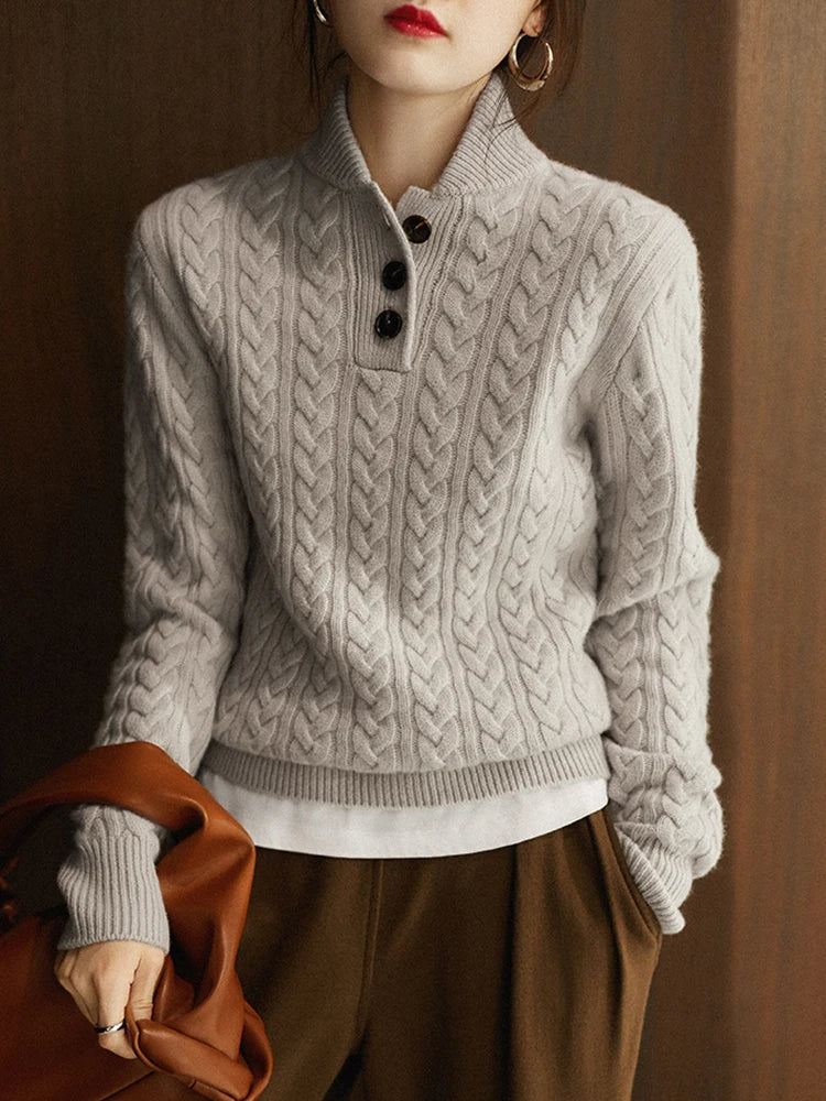 Light gray cable-knit cashmere button-up sweater with black buttons and ribbed hem.
