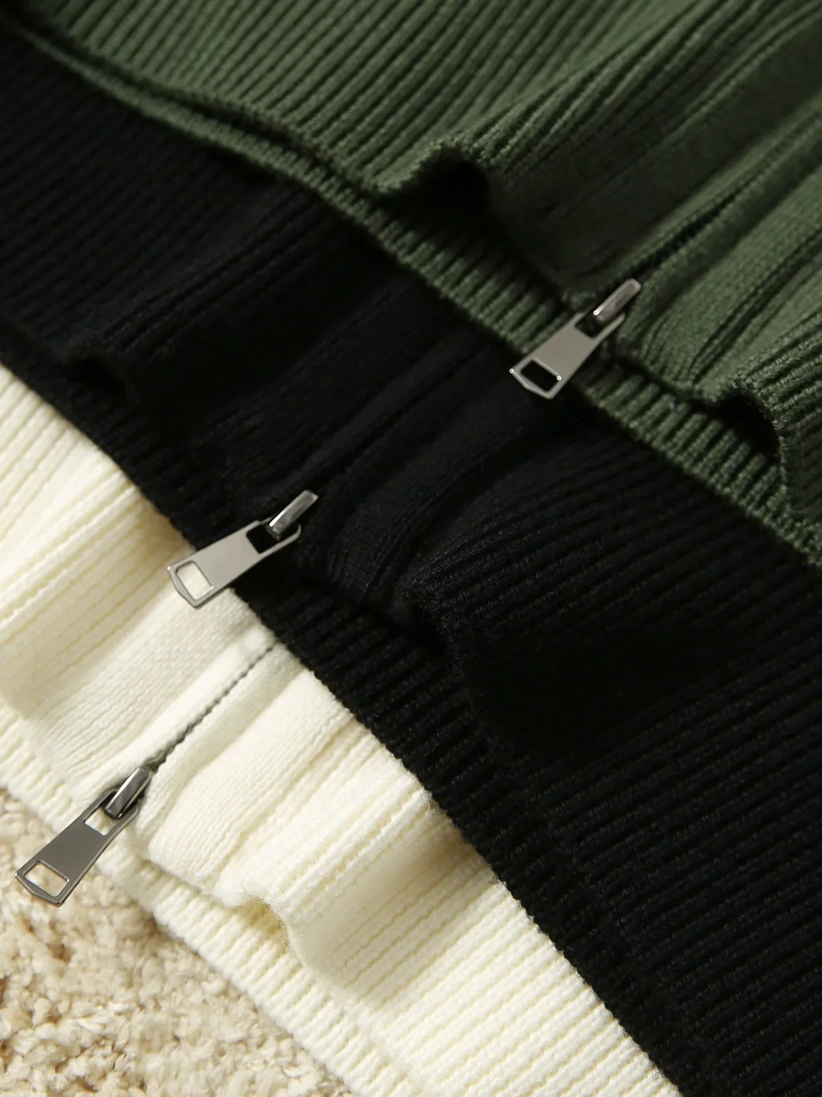 Black zip-up merino wool blend cardigan close-up with metal zipper and ribbed knit