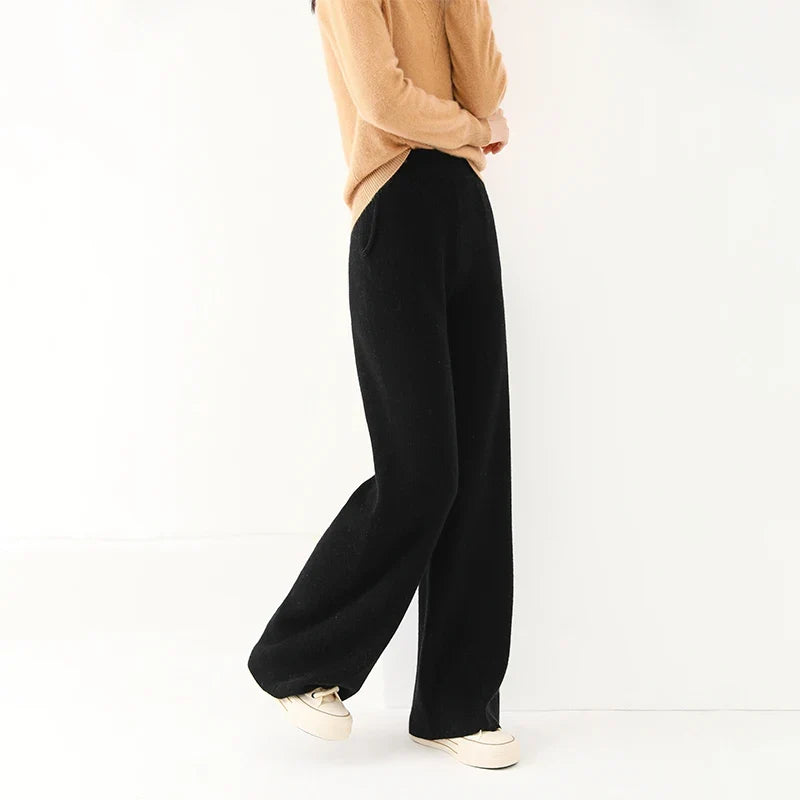 Black wide-leg knit pants, side view, with pull-on waistband and relaxed wide legs.