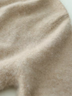 Light beige knit sweater fabric close-up with fine texture and smooth knit surface