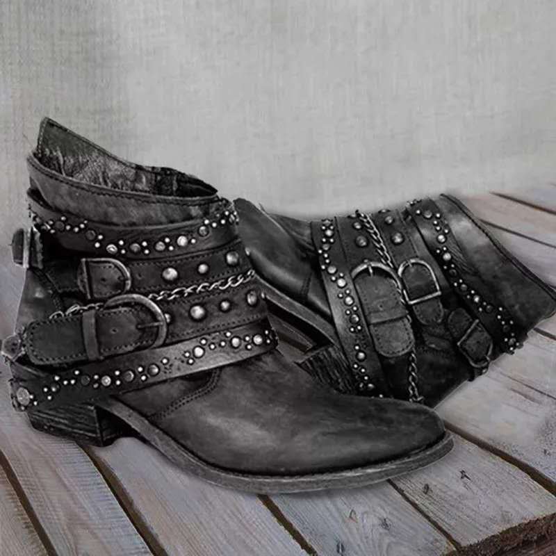 Black vintage ankle boots with studded straps, buckles, and chain accent