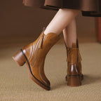 Brown ankle boot showing stacked heel and side zipper with tassel pull