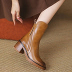 Brown ankle boot with side zipper, tassel detail, and low stacked block heel