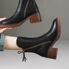 Black ankle boot side view with side zipper, tassel detail, and block heel