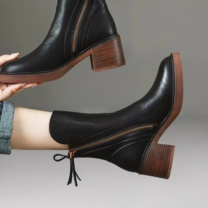 Black ankle boot side view with side zipper, tassel detail, and block heel