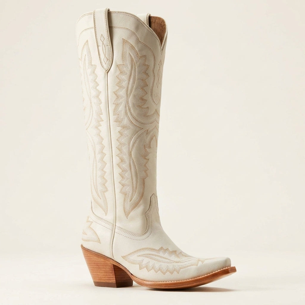 White cowboy boots with embossed western patterns, pointed toe, and wooden block heel
