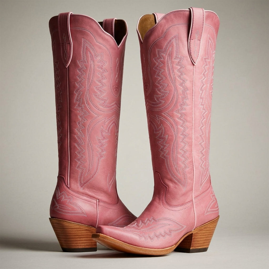 Pink cowboy boots with western stitched design, pointed toe, and stacked wood heel