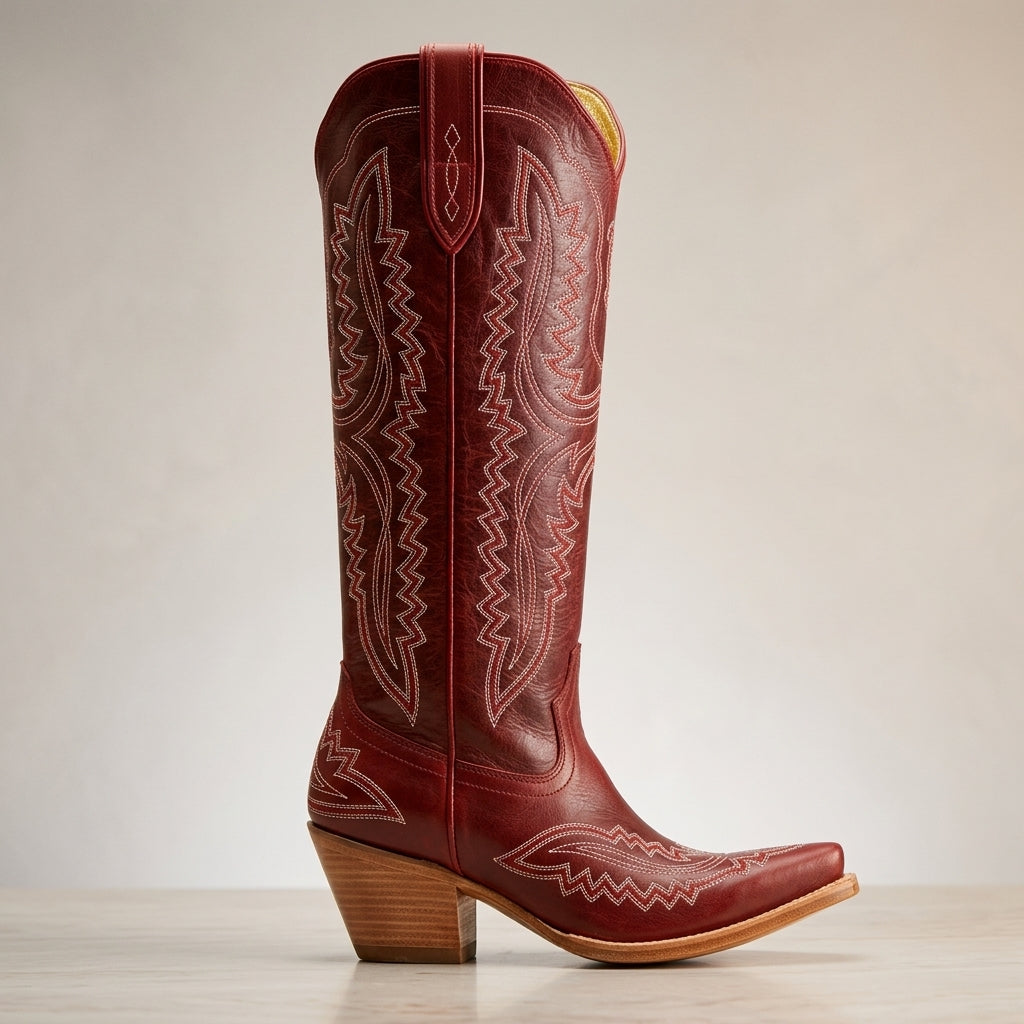 Red cowboy boots with embossed western patterns, pointed toe, and wooden block heel
