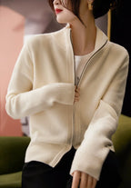 Ivory zip-up cardigan sweater with front zipper and ribbed collar and cuffs.