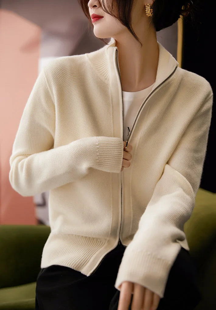 Ivory zip-up cardigan sweater with front zipper and ribbed collar and cuffs.
