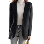 Black wool blazer with notched lapels, single-breasted two-button front, and side pockets