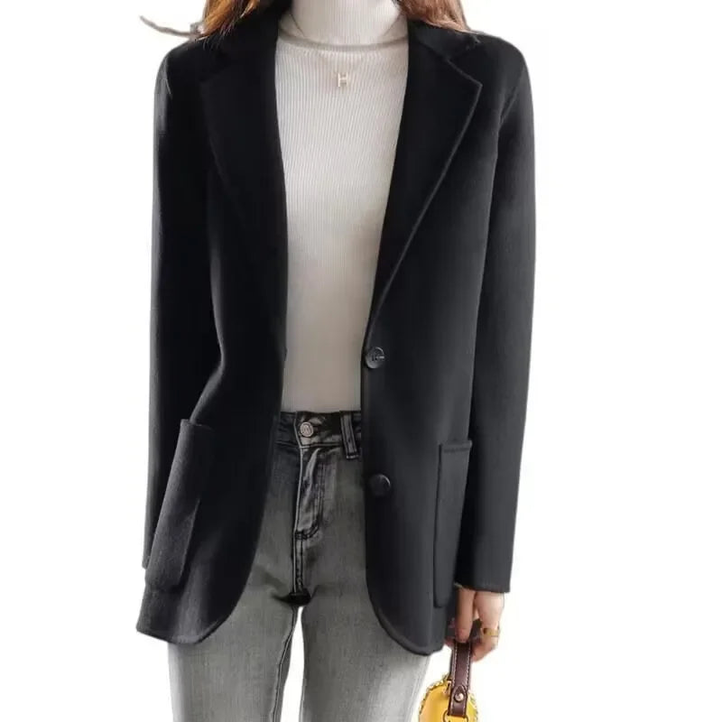 Black wool blazer with notched lapels, single-breasted two-button front, and side pockets
