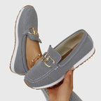 Gray orthopedic loafer shoes showing side profile, textured knit and gold buckle-bit detail