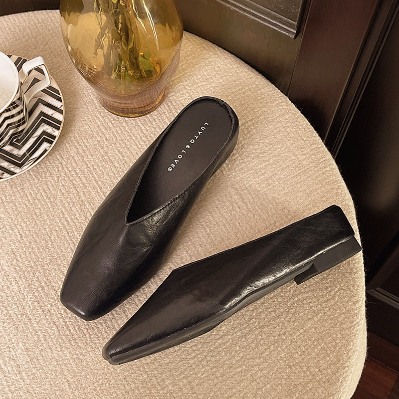 Black leather flats with pointed toe and low heel, slip-on style