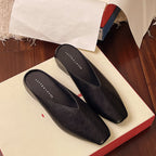 Black leather flats with pointed toe and low heel, slip-on slip