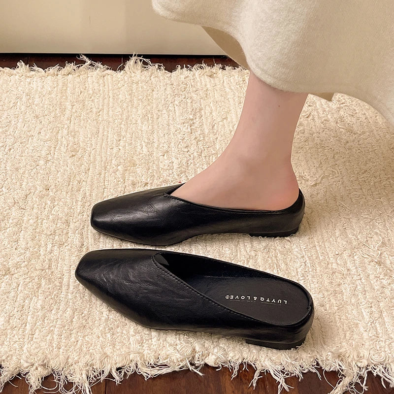 Black leather flats with pointed toe and low heel, slip-on footwear