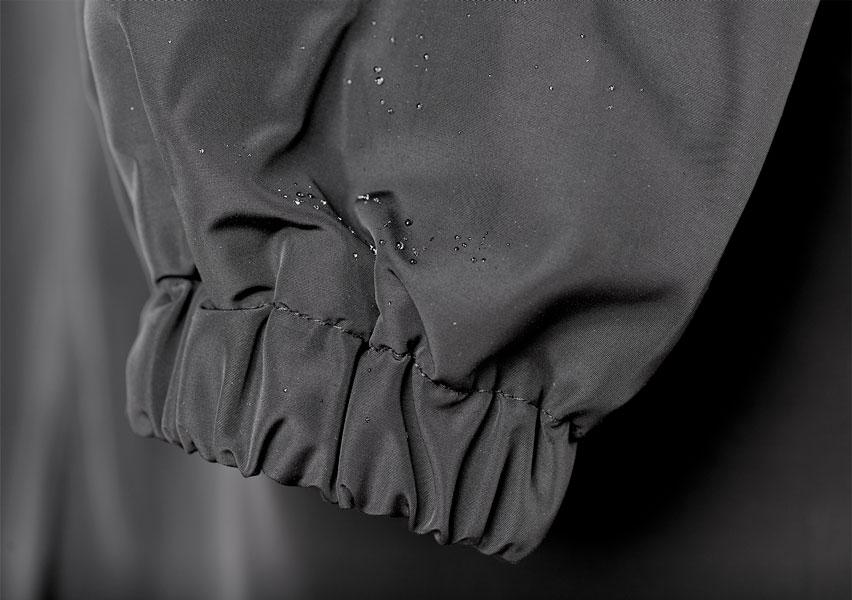 Close-up of grey raincoat cuff with elastic ruching and water-shedding finish