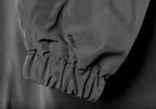Close-up of grey raincoat cuff with elastic ruching and water-shedding finish