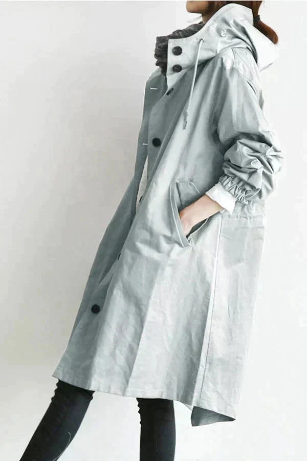 Light grey womens waterproof raincoat with oversized hood and buttoned front