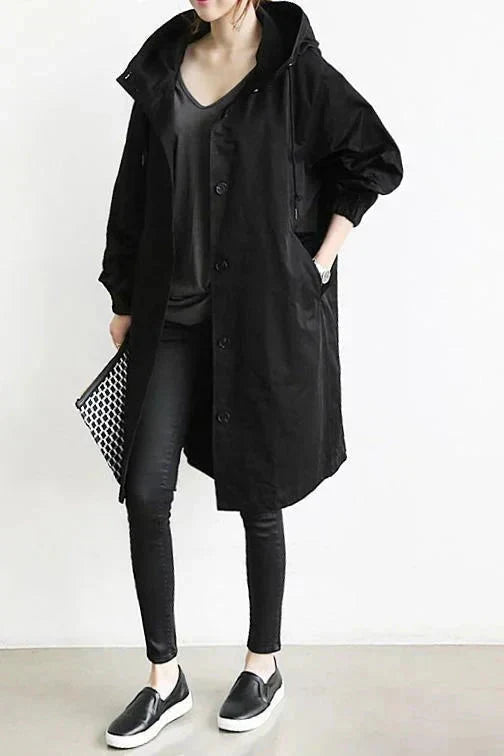 Black womens oversized waterproof raincoat with hood, button front, and side pockets