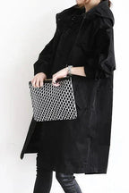 Black womens oversized waterproof raincoat with hood and snap-button front