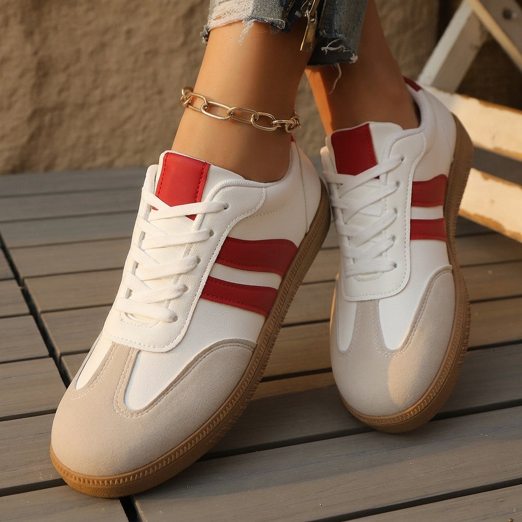 White low-top trainer with red stripe accents and lace-up closure, tan sole.