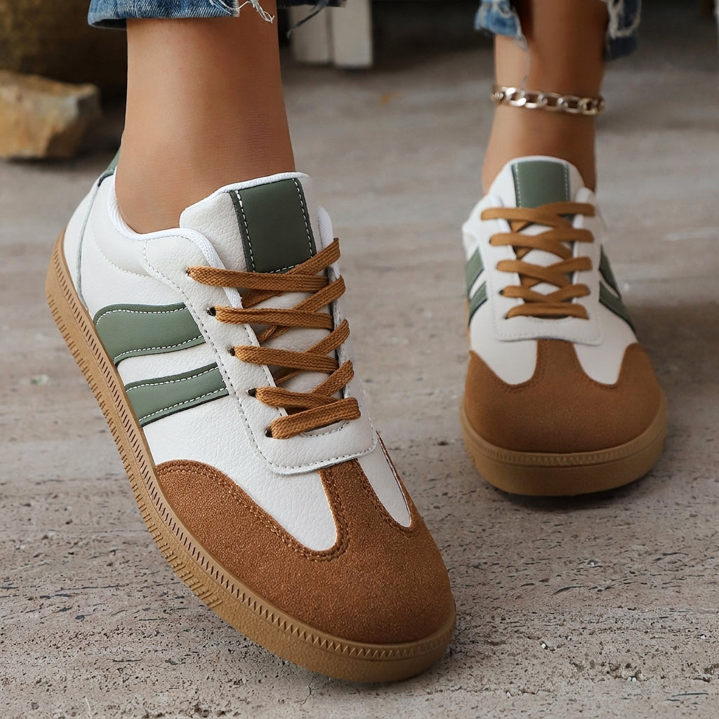 White and green lace-up sneaker with brown suede panels and tan rubber sole.