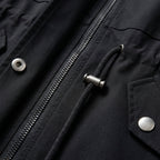 Black zip jacket close-up with metal zipper pull and snap button placket detail