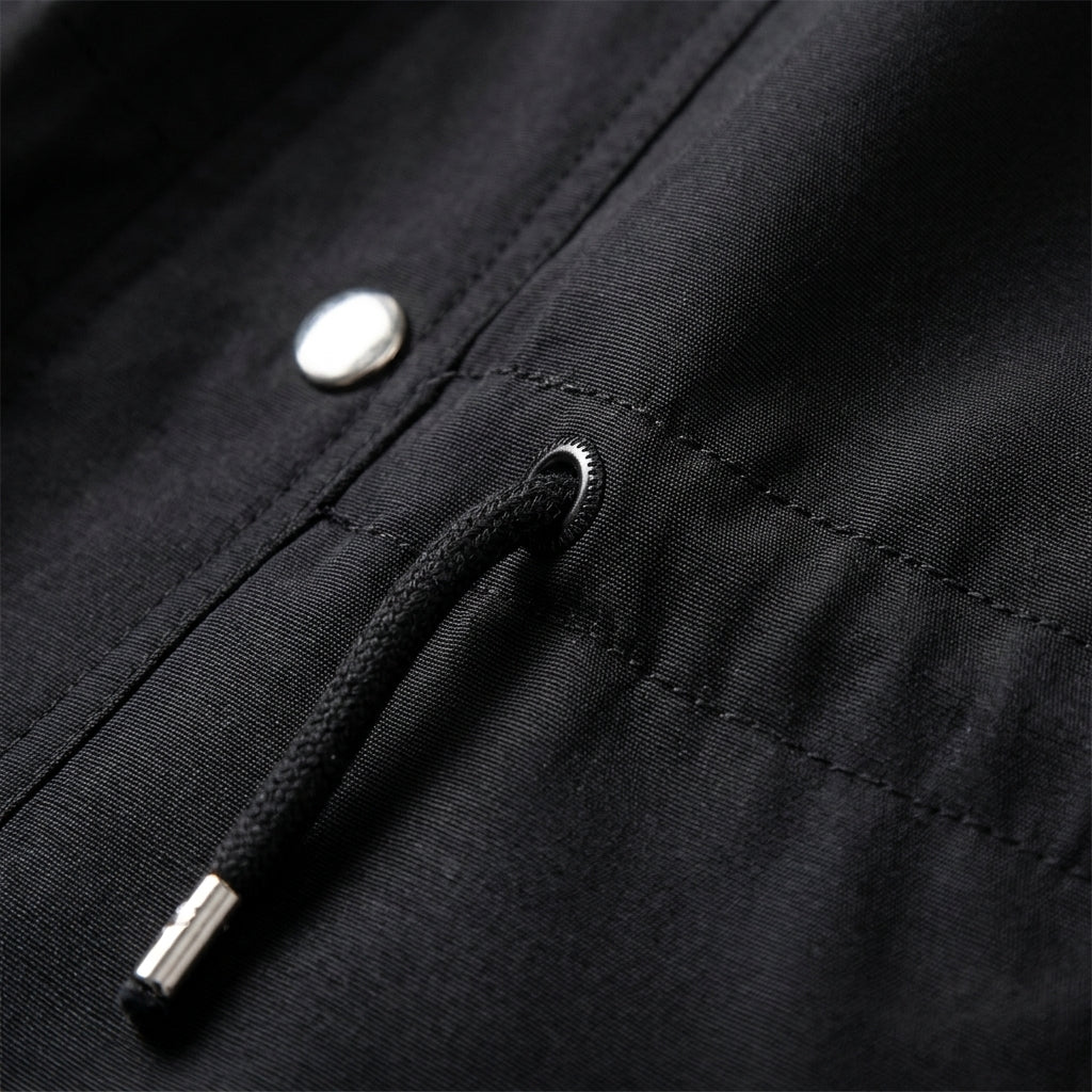 Black jacket close-up with drawstring cord stopper and snap button on pocket panel