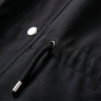 Black jacket close-up with drawstring cord stopper and snap button on pocket panel