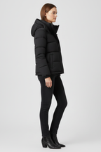 Black hooded insulated puffer jacket worn with dark jeans and boots