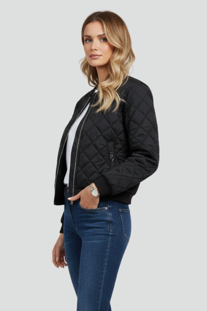 Women's black quilted zip-up jacket, model three-quarter view, diamond pattern, ribbed cuffs