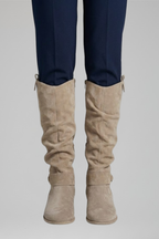 Beige knee-high boots with side seams and ankle strap, low stacked heel.