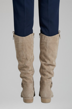 Beige knee-high boots, back view with pull tabs and ankle strap, low stacked heel.