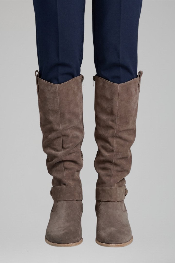 Brown knee-high boots with side zipper and buckle ankle strap, low stacked heel.