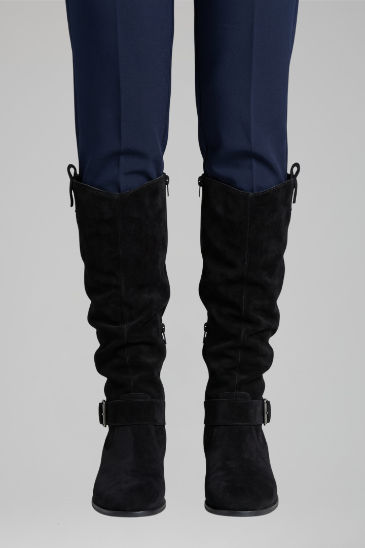 Black knee-high boots with side zipper and buckle ankle strap, low stacked heel.