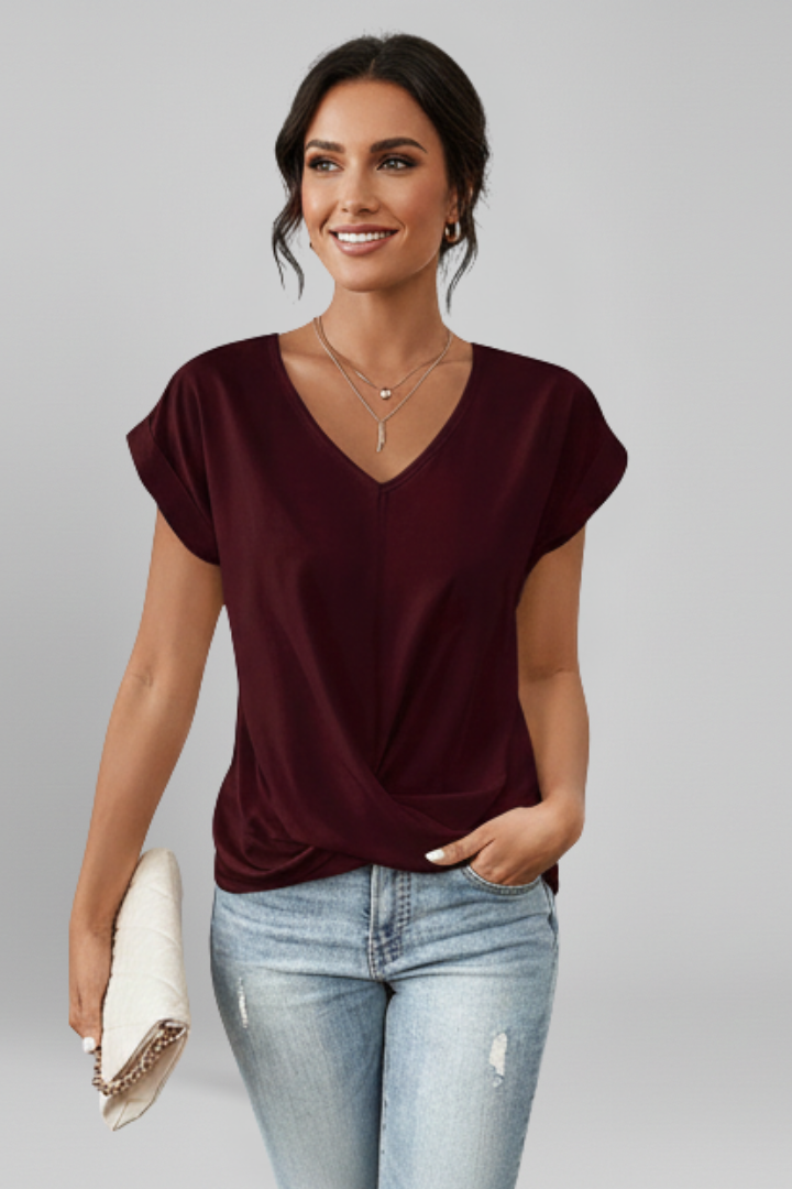 V-neck short-sleeve blouse in burgundy, twisted front drape at waist.
