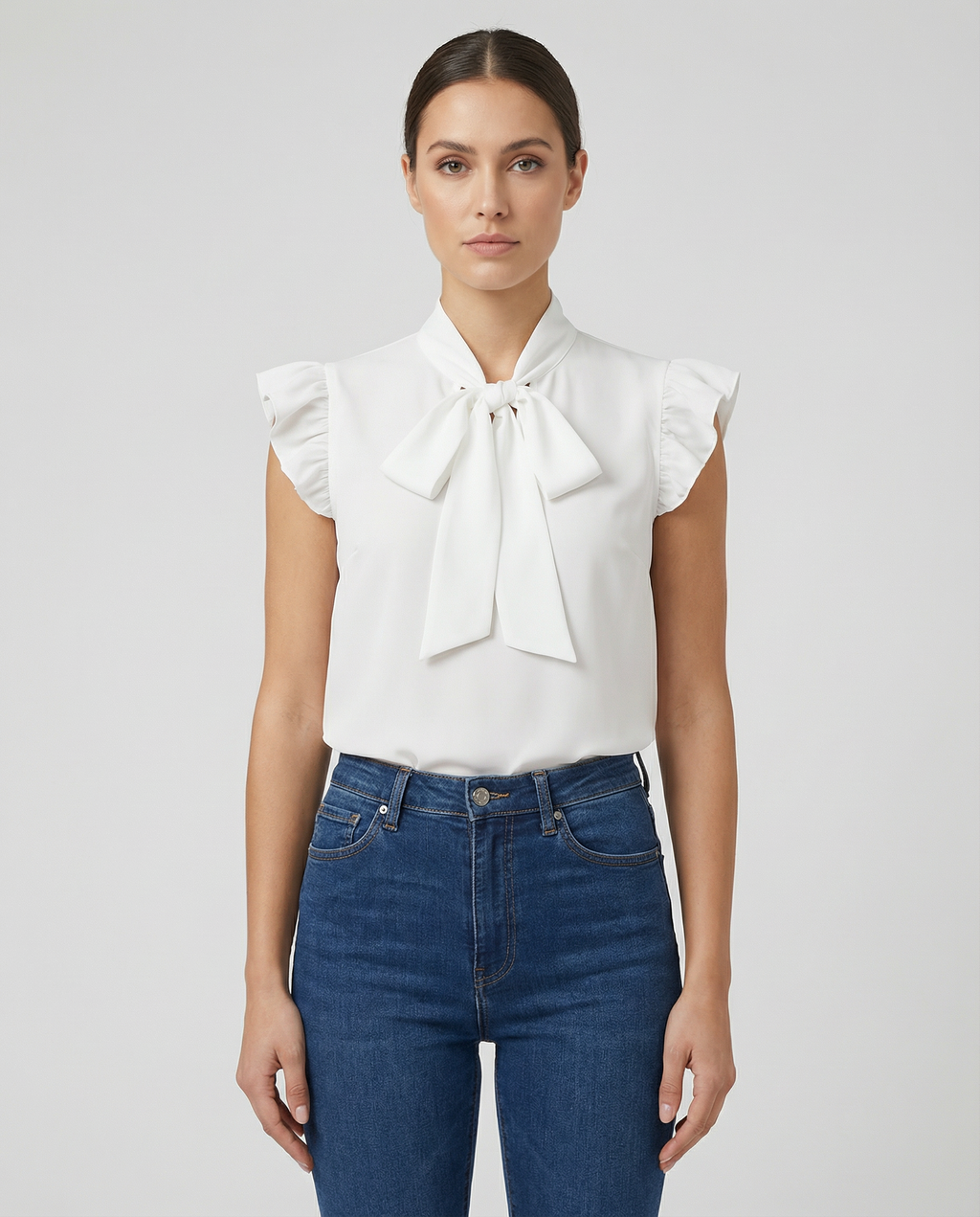 White sleeveless blouse with ruffled sleeves and large bow tie neck detail