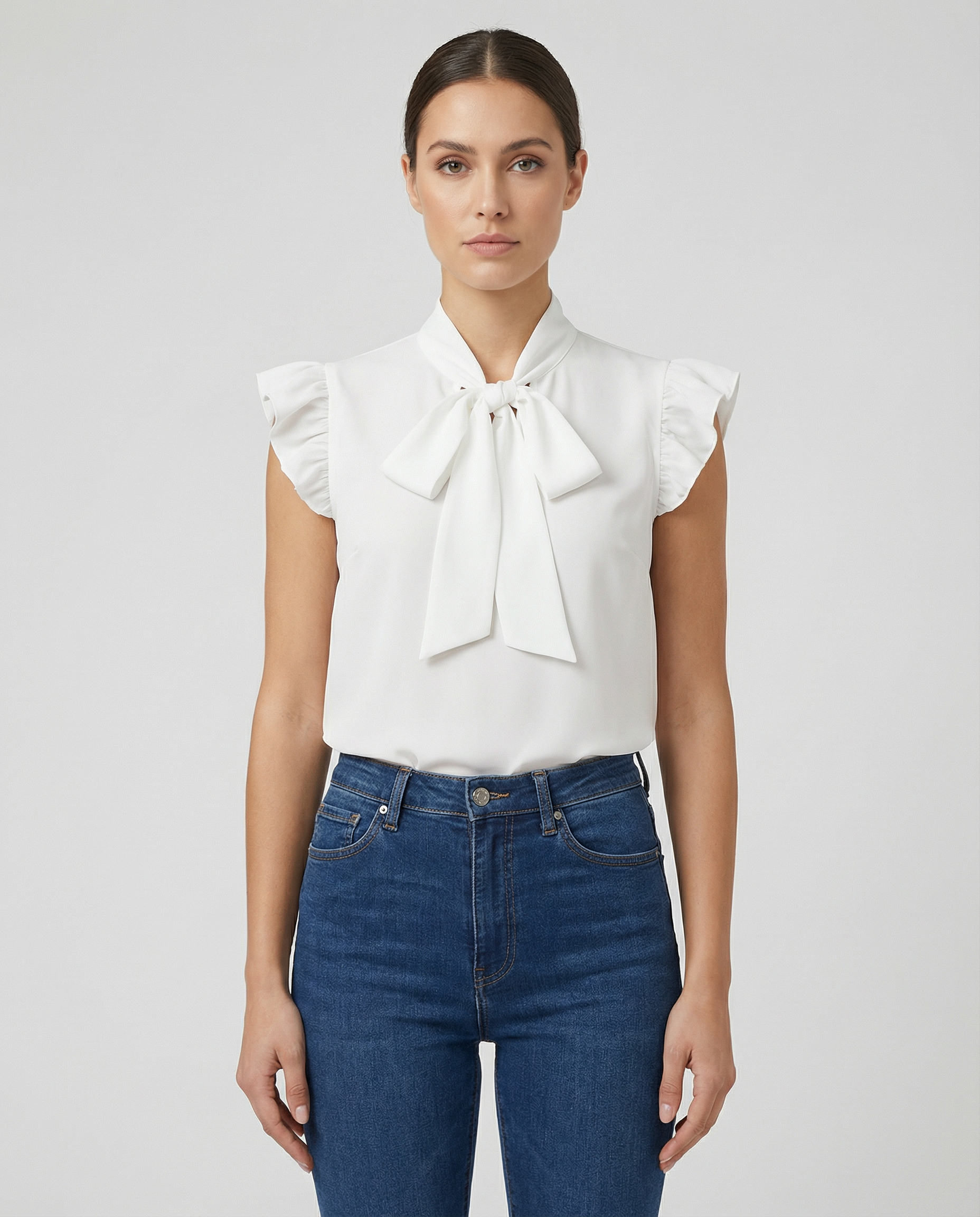 White sleeveless blouse with ruffled sleeves and large bow tie neck detail