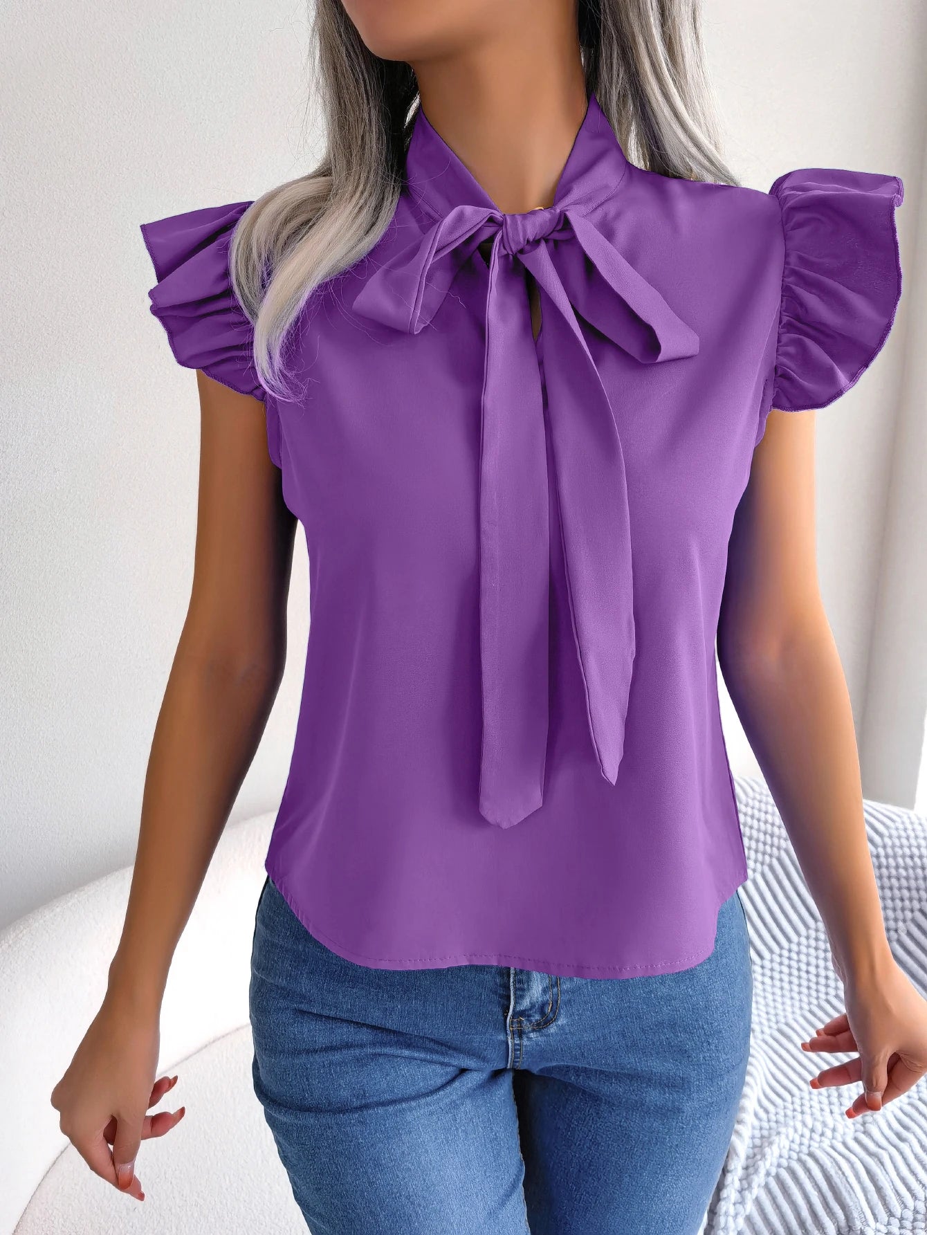Purple sleeveless blouse with bow tie neckline and ruffled shoulder sleeves
